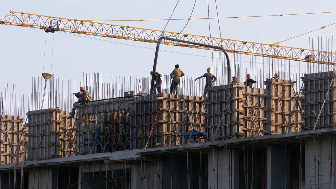 Équipe de travailleurs sur un coffrage de béton avec une grue