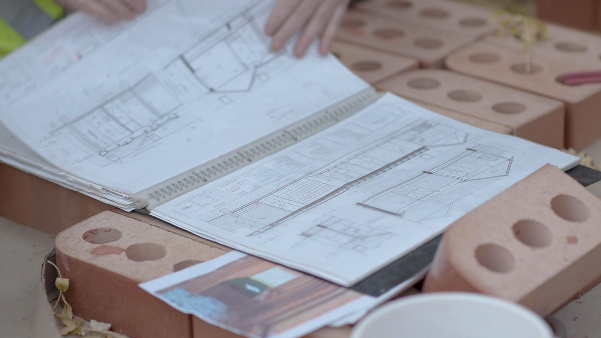 Plans de construction et devis étalés sur un chantier